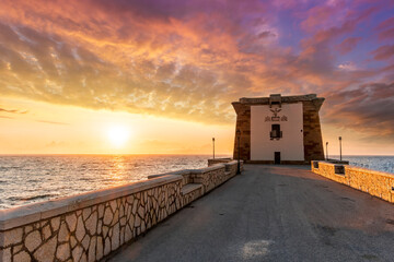 beautiful sunset or sunrise at beautiful embarkment with nice tower on a cape point of a promontory...