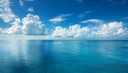 Obraz premium serene azure seascape under bright sunshine with billowing clouds casting shimmering reflections over tranquil expanse