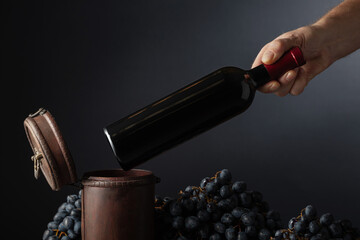 Sommelier places a bottle of red wine in an old wooden box.