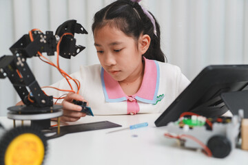 A smart child learning to code and build a robot with online resources.