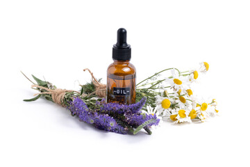 Essential oil with chamomile wildflowers on a white background. Aromatherapy.