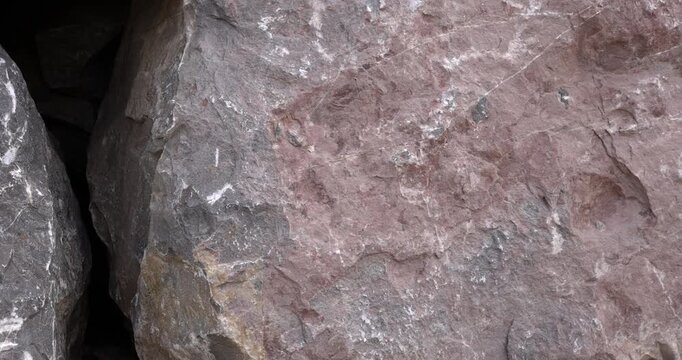 Jagged weathered red rock closeup with white mineral streaks and nicks slider camera motion