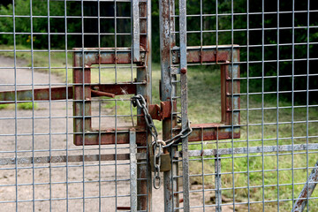 Rusted Padlocked Steel Entrance Gate at an Abandoned Industrial Facility