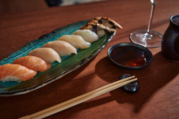 A Delicious Display of Sushi Varieties Featuring Fresh Fish, Perfectly Rolled Rice, and Accompanying Soy Sauce on a Wooden Table Setting
