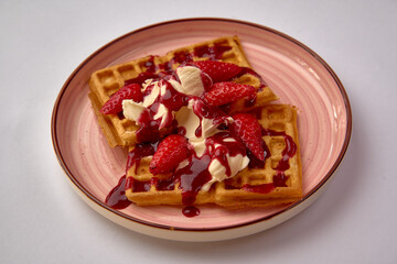 Deliciously Crafted Waffles Topped with Fresh Strawberries, Creamy Whipped Topping, and a Generous Drizzle of Sweet Syrup on a Decorative Plate