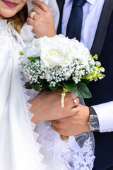 Cropped shot of an unrecognizable bride and groom standing together and holding flower Bouquet.