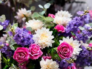 Colorful floral arrangement with pink roses, white dahlias, and purple blooms