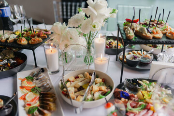 Catering service on banquet table with canape snacks in restaurant or hotel. Decorated food set on...