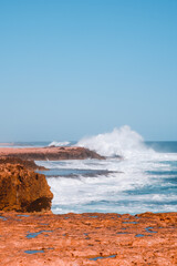 Waves crashing on red coastal rocks in Australia