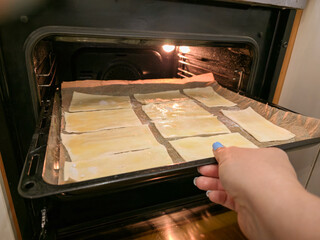 Homemade baked goods in the oven from dough. Puff pastry. Concept of home baking or dough...