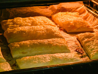 Homemade baked goods in the oven from dough. Puff pastry. Concept of home baking or dough preparation