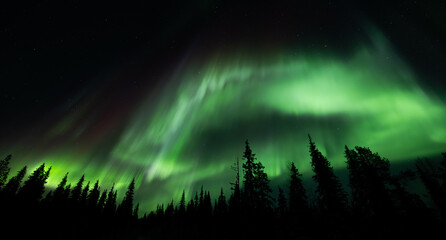 Northern lights, aurora borealis in the night sky over frozen lake in Lapland, Finland