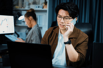 Businessman looking on laptop while calling to broker with calculating value margin of profit for...