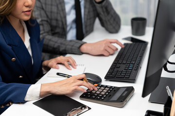 Cropped hands businessman with coworker calculating with calculator manual's financial and...