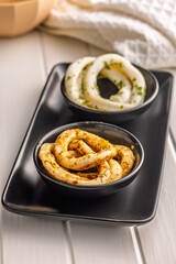 Marinated squid rings in bowl on white table.