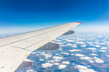 View from the airplane window at a beautiful cloudy sky and the airplane wing