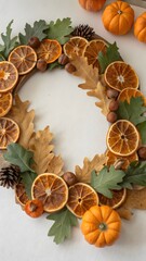 Dried Orange Slices Wreath with Oak Leaves Hazelnuts and Pumpkins on White Surface