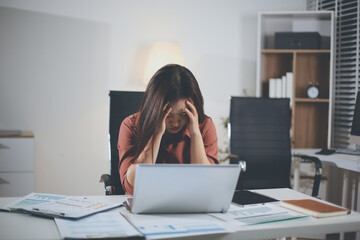 Tried young Asian office employee feeling sick and have a headache from a long working day at office