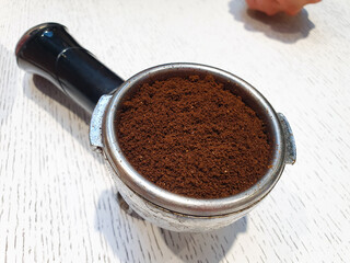 Holder metal with ground coffee. Natural coffee in the holder, coffee preparation.