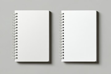 Two blank spiral-bound notebooks side-by-side on a gray surface