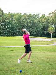 Fototapeta premium White male golfer in his 40s chipping the ball.