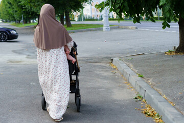 Mother walking with stroller on a quiet street during the day in a serene neighborhood