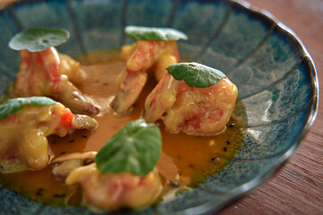 Delicately Presented Gourmet Shrimp Dish with Fresh Greens and Rich Sauce on a Decorative Plate