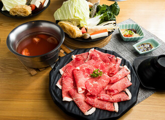 Beef Shank Hot Pot including Sliced Raw Meat with Fresh Vegetables and Broth side view of Asian food
