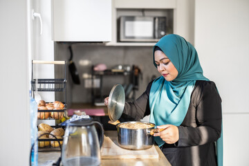 Smiling Muslim Woman in Hijab Standing in Kitchen at Home
