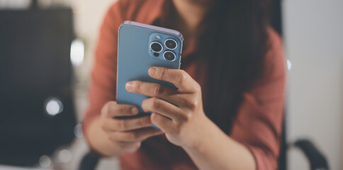 Closeup image of a businesswoman using mobile phone in office