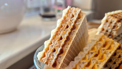 Close-up view of stacked crispy wafers with a rich filling, placed on a surface. Perfect for showcasing desserts or snacks in culinary presentations.