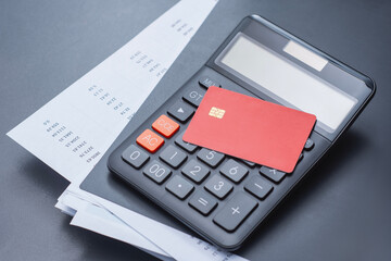 Red credit card with calculator and a payment schedule. Financial concept for credit card usage,...