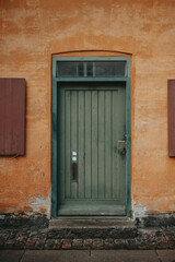 Une porte verte sur un mur orange