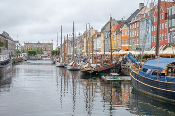 Fototapeta premium Les maisons colorées sur les rives du canal Nyhavn, au cœur de la ville de Copenhague au Danemark, avec des bateaux