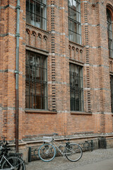 Fa&ccedil;ade typique en briques de Copenhague avec fen&ecirc;tres industrielles et v&eacute;lo stationn&eacute; 