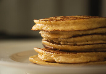 Homemade pancakes stack on white kitchen table with grey background, close up. Pancake day.