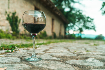 Glass of Red Wine in Front of Stone Wine Cellar in France or Italy