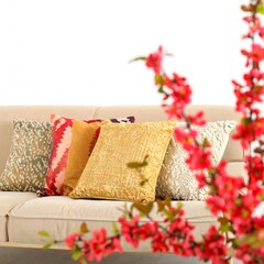 Colorful decorative pillows on a couch with cherry blossoms