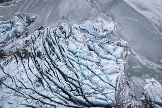Aerial view of the fractured, icy landscape of S&Atilde;&sup3;lheimaj&Atilde;&para;kull Glacier, a symphony of blues and whites, carved by time and nature, V&Atilde;&shy;k &Atilde;&shy; M&Atilde;&frac12;rdal, M&Atilde;&frac12;rdalshreppur, Iceland.