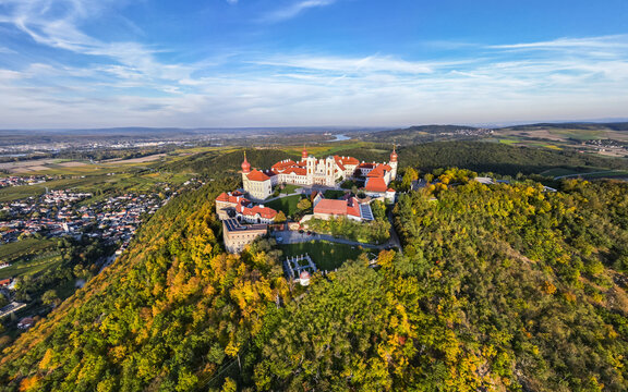 Aerial view of G&Atilde;&para;ttweig Abbey perched atop a hill, its terracotta roofs contrasting with the autumnal foliage and the distant blue horizon, Krems, Nieder&Atilde;&para;sterreich, Austria.
