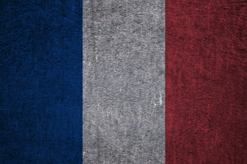 Fototapeta premium French flag on a textured uneven wall, patriotic photo