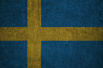 Swedish flag on a textured uneven wall, patriotic photo