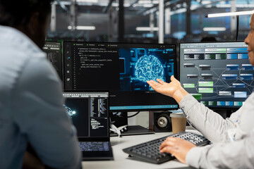 Engineering team inspecting neural network data center used for machine learning. Teamworking colleagues doing maintenance on server hub to optimize it for artificial intelligence workloads
