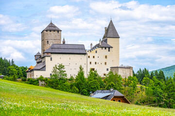 Mauterndorf Castle stands majestically against a backdrop of lush greenery and rolling hills. © pyty
