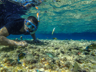 Young man wearing goggles ( mask ) swimming and diving underwater with fishes enjoying summer vacation in the Mediterranean Sea, sports activity concept, Scuba snorkeling in barrier reef sea ocean.