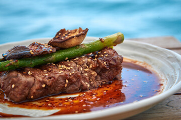 Savor the Flavors of Grilled Steak with Fresh Asparagus and a Rich Sauce Served on a Plate Against...