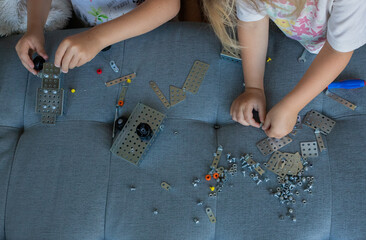 Children assemble a construction set, view from above