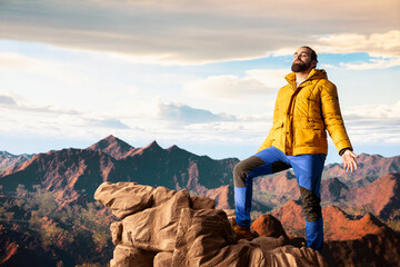 Adventure seeker in warm clothing enjoys the serenity of the wilderness, panoramic mountain top...
