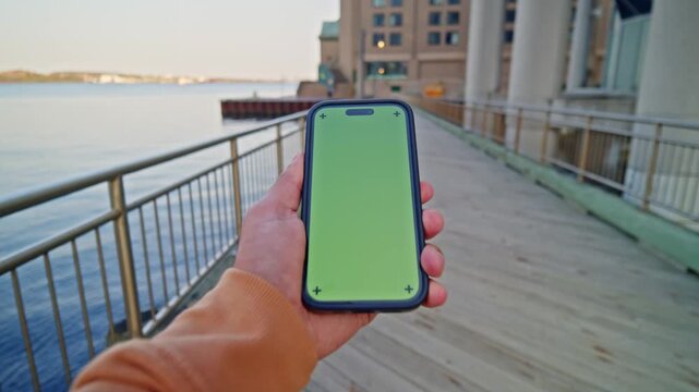 Clear View Of Phone With Chroma Key Display In Daylight. Downtown City Vibes With Motion Blur Show Fast-Paced Life. Ideal For Mobile Apps, Finance, Or Navigation Concepts.