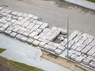 Large stacks of paving slabs prepared for road and sidewalk construction at an urban construction...